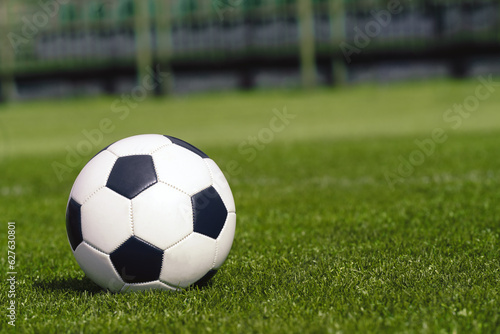 Football Ball on the Grassy Turf of the Stadium. Soccer Ball on Grass Soccer Field. Sports Pitch in Blurred Background