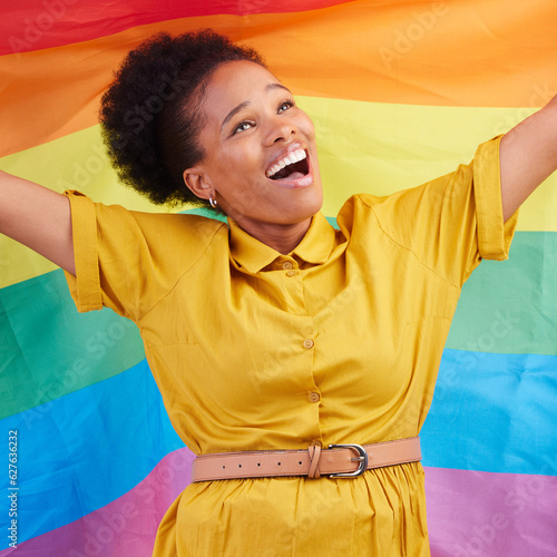 Pride, flag and happy black woman in studio for gay, rights and lgbtq life or choice. Rainbow, freedom and lesbian African female celebrating, smile and confident with inclusion and support