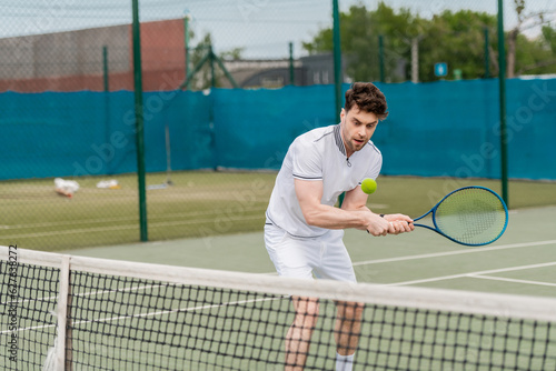 handsome man playing tennis on court, summer hobby and sport, motivation, sportsman © LIGHTFIELD STUDIOS