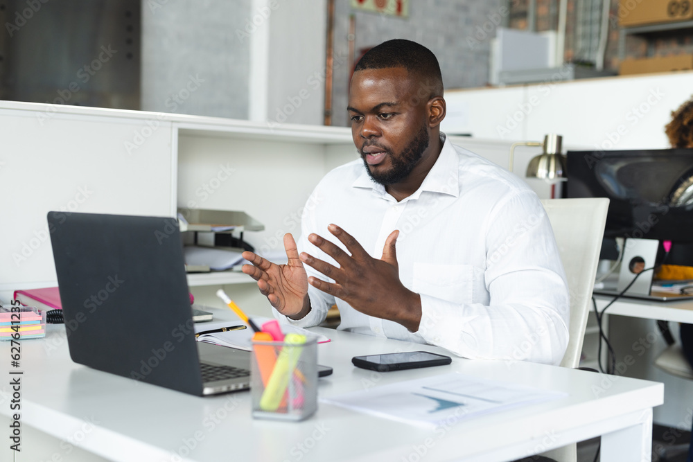 Focused african american casual businessman having laptop video call in office Focused african american casual businessman having laptop video call in office