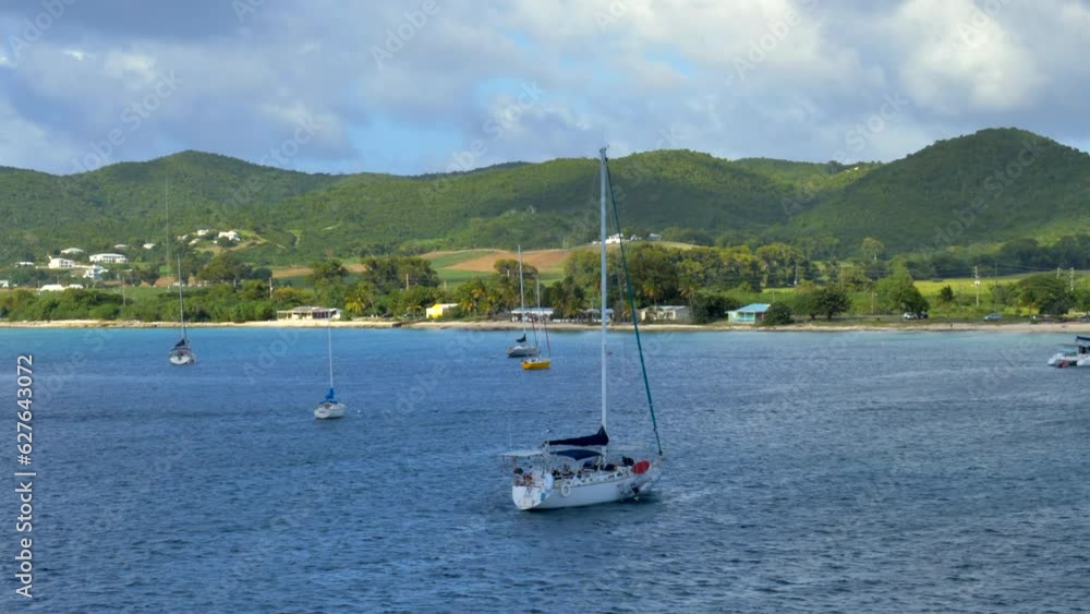 slow sliding motion on sailboat docked in bay. Island background. Mid day slow sliding motion on sailboat docked in bay. Island background. Mid day