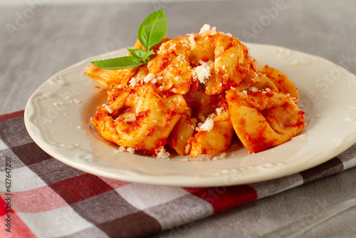 Traditional homemade italian dish - tortellini with tomato sauce and parmesan cheese