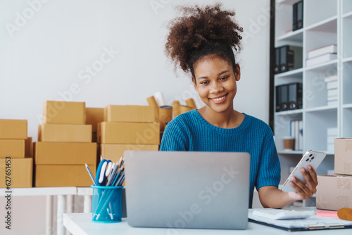 Pretty African American sme business woman working Custom Ecommerce Packaging leading supplier of custom packaging. create a personalised experience, fast production and competitive pricing photo