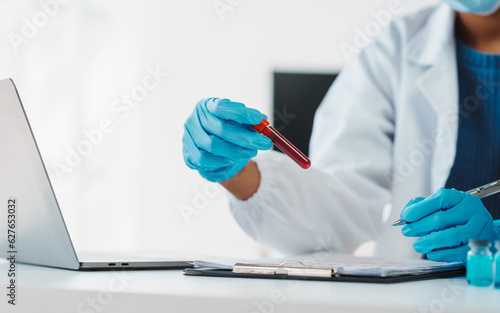 African American female technician testing blood sample in lap. blood test is one of the most common tests healthcare provider uses to monitor your overall health or help diagnose medical condition.