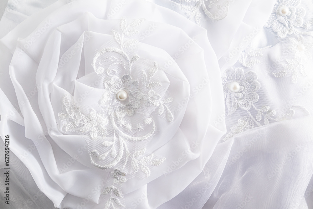 Soft airy fabric flower close-up. details of the bride's wedding white dress. Wedding background. abstract silk background. Soft airy fabric flower close-up. details of the bride's wedding white dress. Wedding background. abstract silk background.