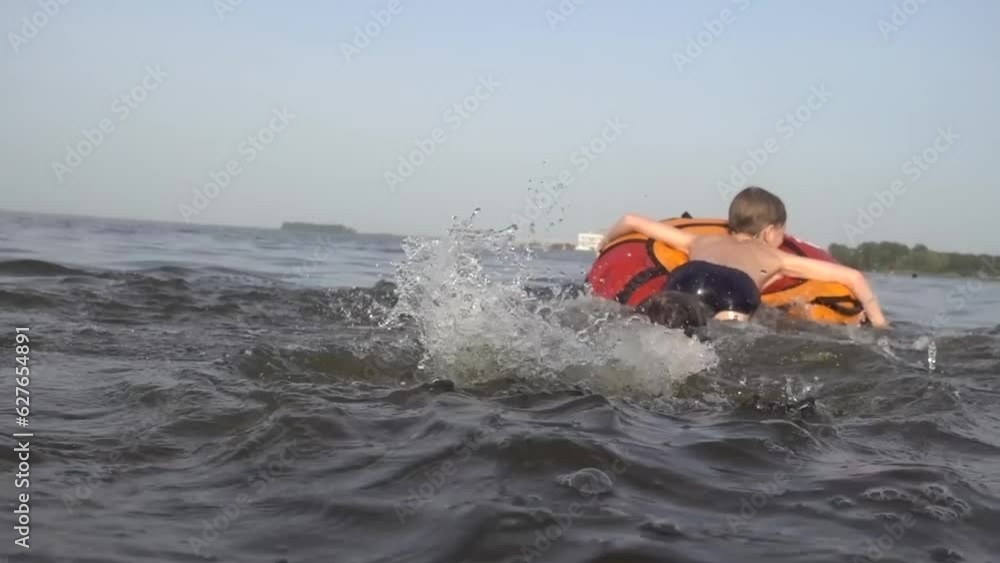 Children play in the water with an inflatable ring. Children play in the water with an inflatable ring.