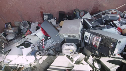 Broken PC and CD player thrown onto heap of other discarded electronics. Slider