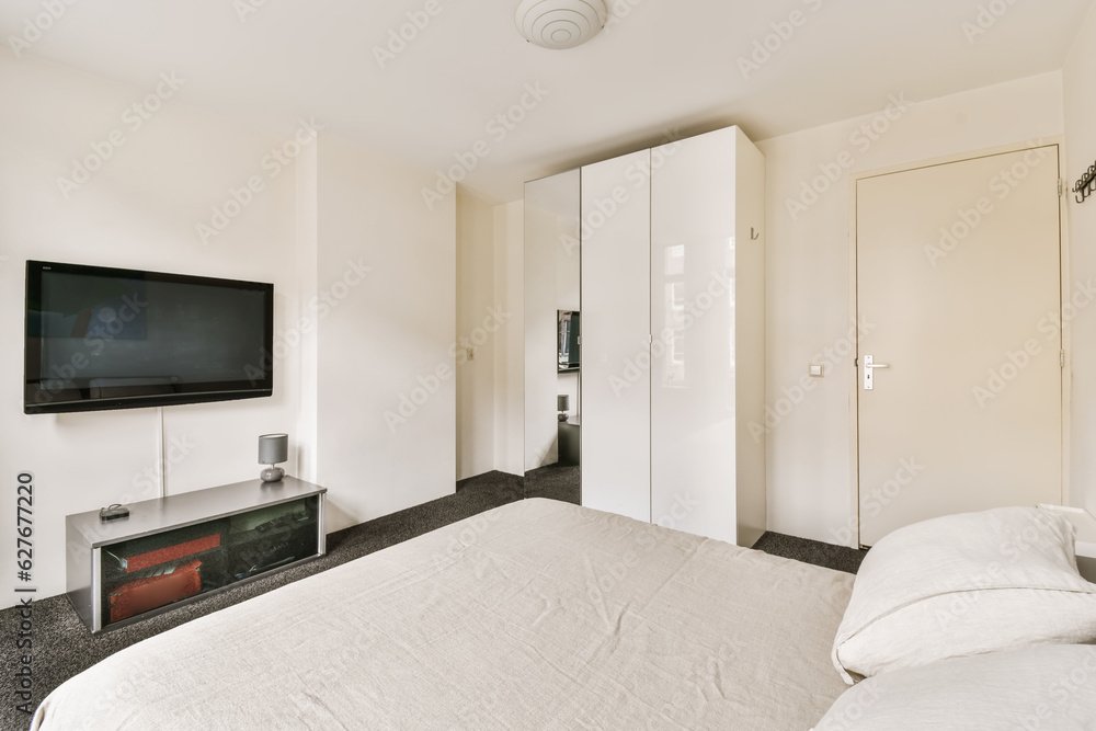 a bedroom with a flat screen tv on the wall and white bedding in front of the television is mounted a bedroom with a flat screen tv on the wall and white bedding in front of the television is mounted