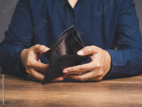 Photography Close-up of hands opening an empty wallet while sitting at the table