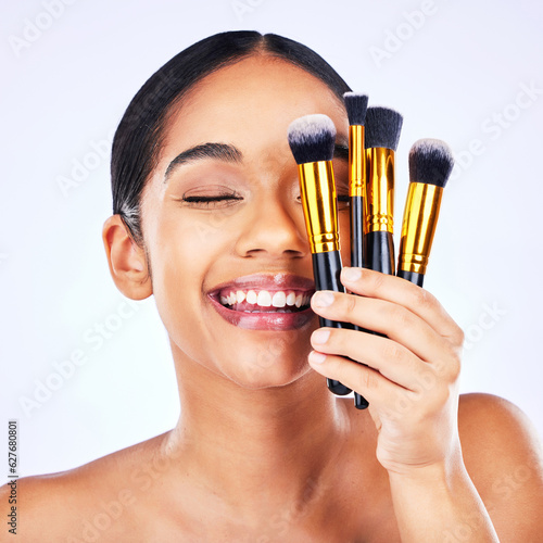 Makeup brush, beauty and cosmetics of a happy woman in studio for skincare, self care and cosmetology. Skin glow, shine and wellness of a female model with facial application tools for foundation