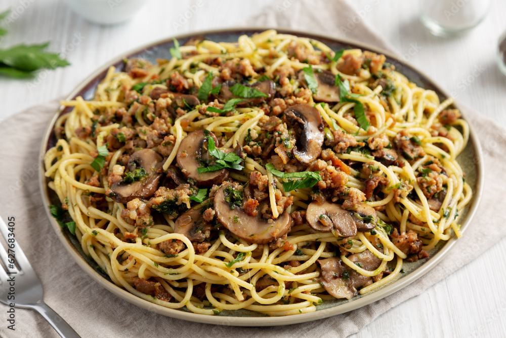 Homemade Mushroom, Spinach & Sausage Spaghetti on a Plate, side view. Close-up. Homemade Mushroom, Spinach & Sausage Spaghetti on a Plate, side view. Close-up.