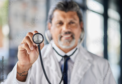 Man, portrait and doctor with stethoscope for cardiology exam, healthcare service and support or check. Heart, listening and medical professional or senior person with clinic or hospital consultation