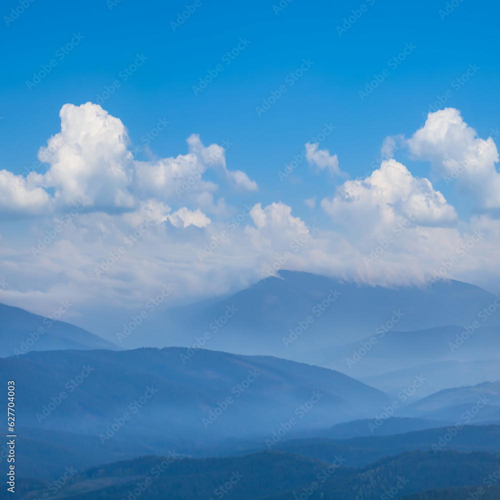 mountain ridge in blue mist and dense clouds