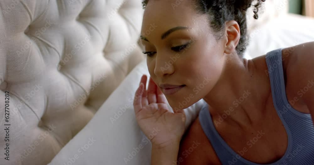 Biracial woman taking nap in bed in bedroom, slow motion Biracial woman taking nap in bed in bedroom, slow motion