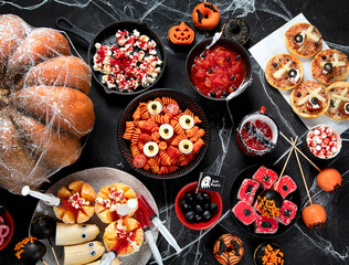 Halloween sweets for Halloween party on black background. top view
