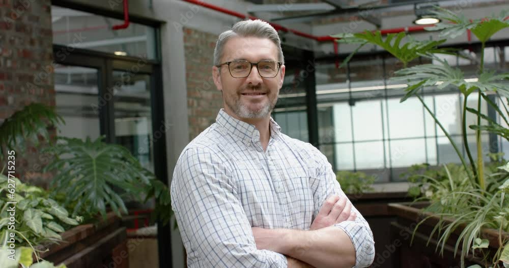 Portrait of caucasian man with arms crossed smiling in the balcony at office Portrait of caucasian man with arms crossed smiling in the balcony at office