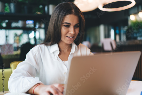 Cheerful woman working on startup project on laptop