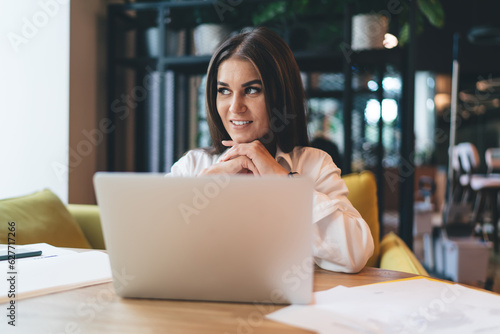 Smiling woman working on business plan with laptop