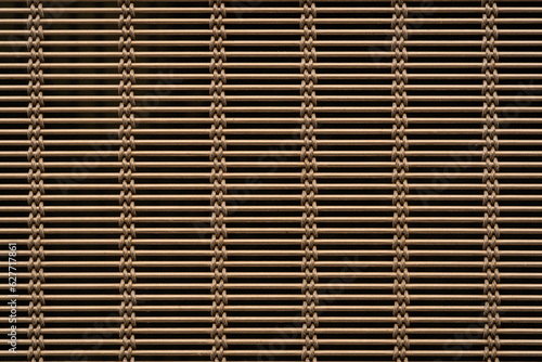 Closeup view of golden brown woven metal blind - background with textured pattern