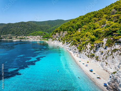 Aerial view of the beautiful Hovolo beach, Sporades, Greece, with turquoise sea and lush pine tree forest