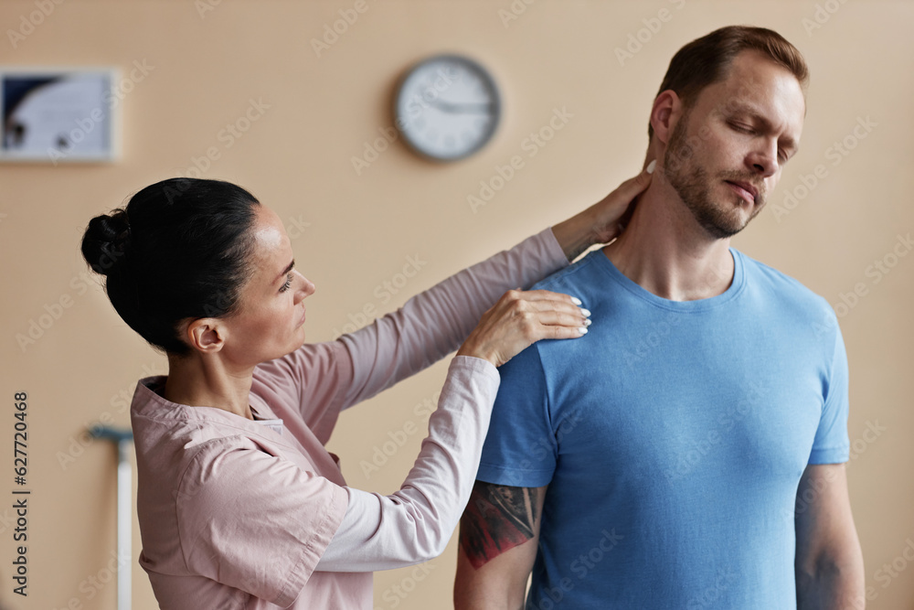 Manual therapist massaging pain neck of patient during physiotherapy in hospital Manual therapist massaging pain neck of patient during physiotherapy in hospital