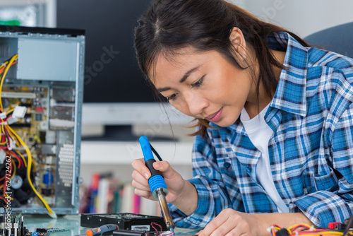 female computer technician using soldering iron