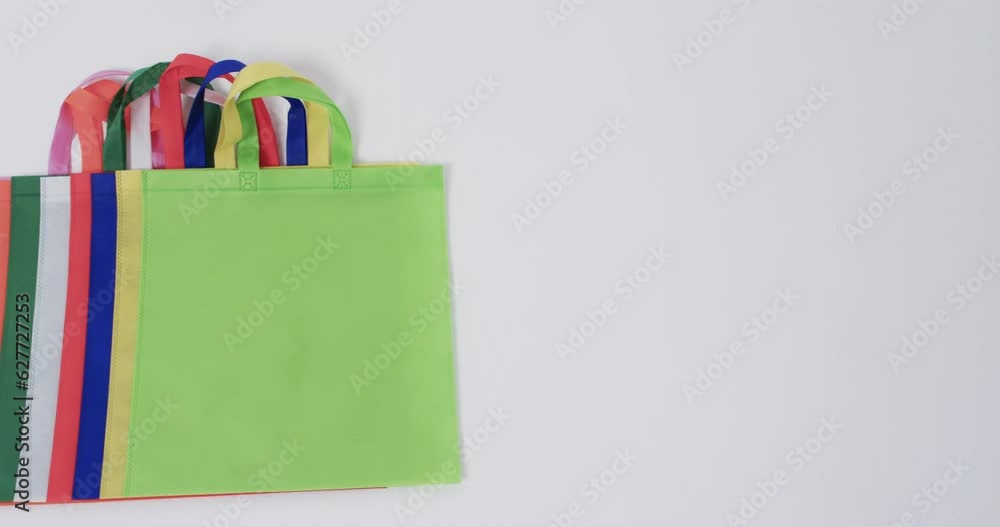 Video of multi coloured canvas bags with copy space on white background