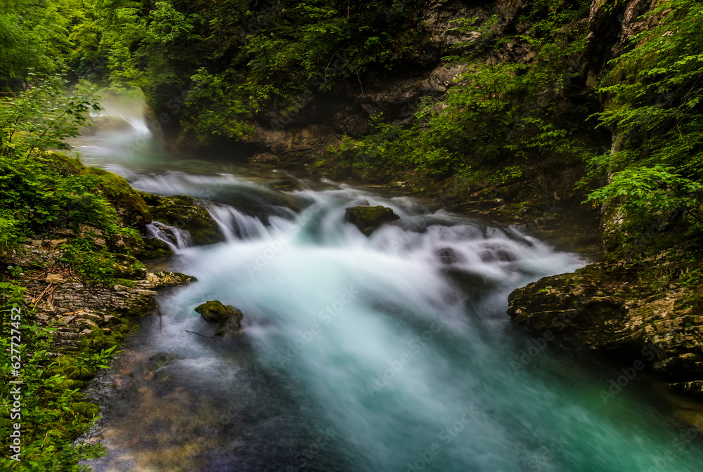 A long exposure view of the Radovna River flowing over a fall in the Vintgar Gorge in Slovenia in summertime A long exposure view of the Radovna River flowing over a fall in the Vintgar Gorge in Slovenia in summertime