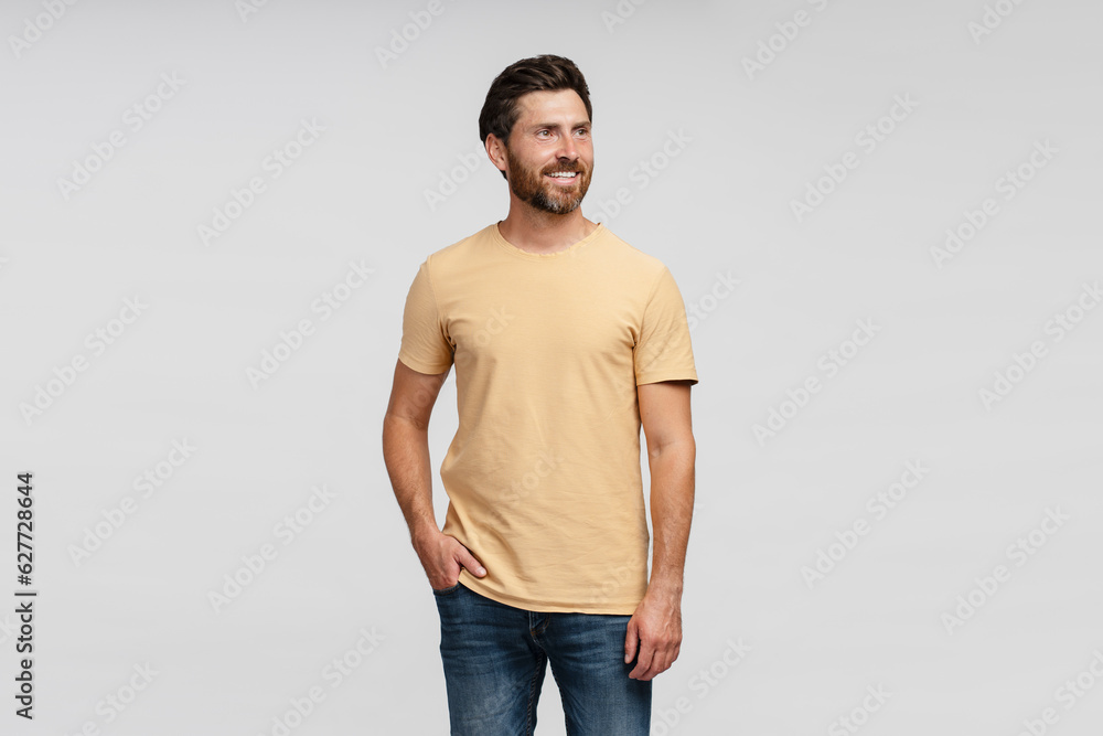 Smiling hispanic man wearing casual t shirt looking away isolated on grey background. Handsome young guy standing posing for a picture, advertisement. Mockup Smiling hispanic man wearing casual t shirt looking away isolated on grey background. Handsome young guy standing posing for a picture, advertisement. Mockup