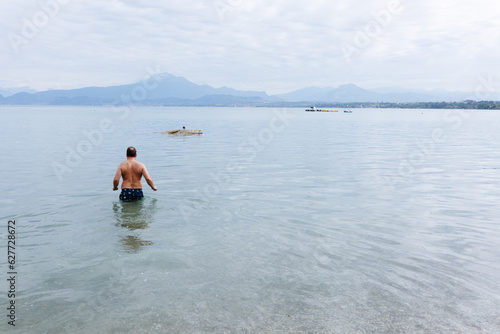 rear view of man entering water to swim in the lake © Victoria