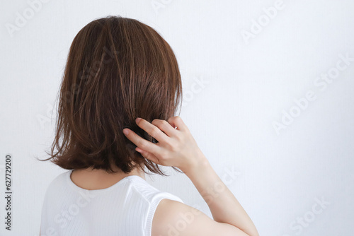 髪の毛を触る女性 ヘアケアイメージ