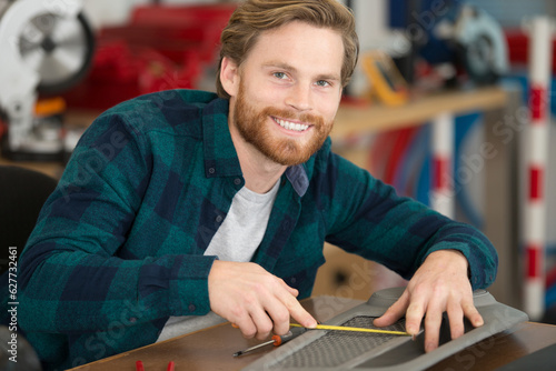 handsome young mechanic smiling at camera photo