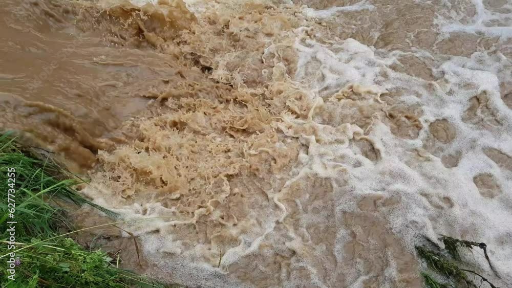 Muddy dirty water mixed with sewage flowing after heavy rains and floods in the city Muddy dirty water mixed with sewage flowing after heavy rains and floods in the city