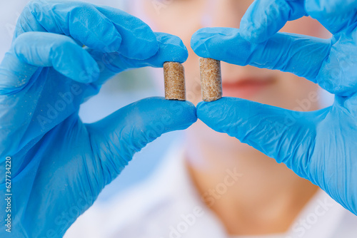 Φωτογραφία Woman worker control pellet combined feed for production food for animal in labo