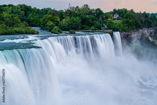 A long exposure photo of the American - Canadian waterfalls Niagara Falls in dusk.