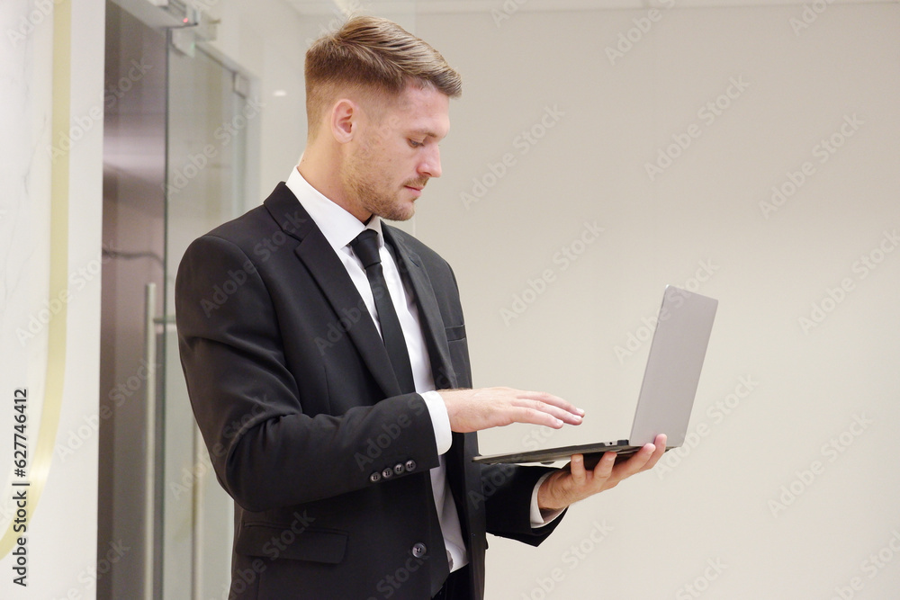 Businessman standing with laptop looking at business information. Businessman standing with laptop looking at business information.