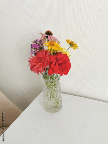 Bright bouquet of flowers on the table in a glass vase.
