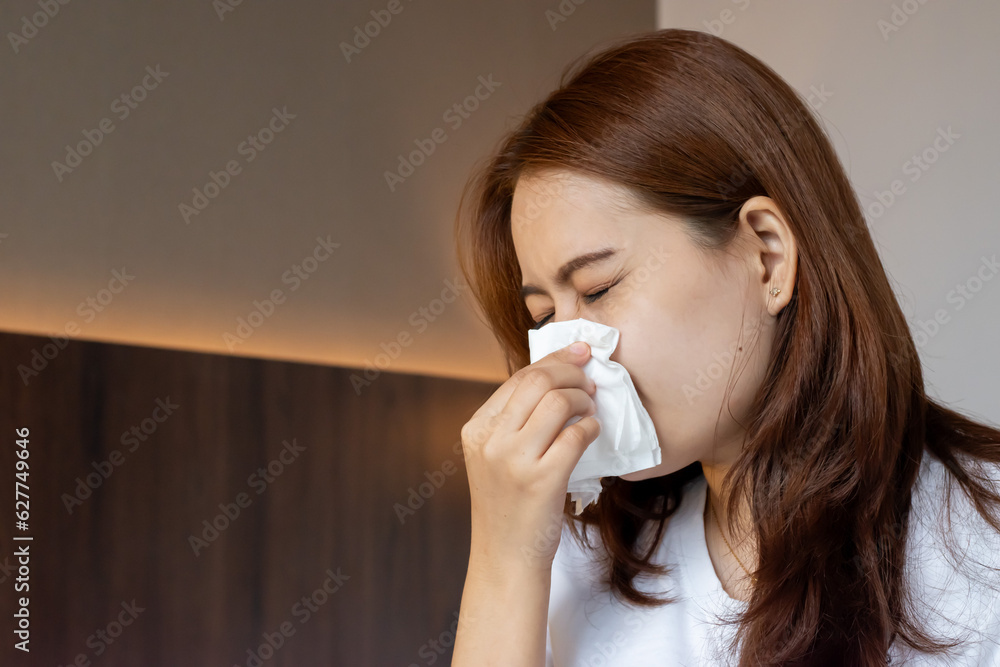 Asian woman suffering from runny nose or nasal blocking. Common cold or flu patient with rhinitis Asian woman suffering from runny nose or nasal blocking. Common cold or flu patient with rhinitis