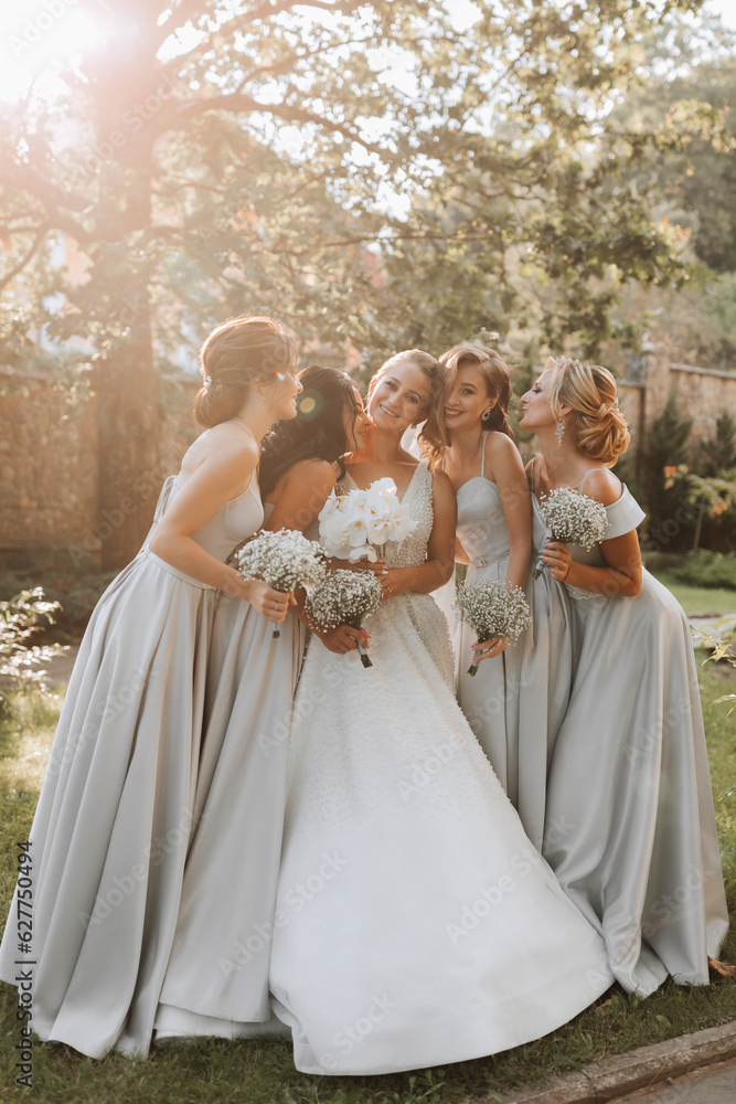 Group of beautiful girls with bride in matching dresses smiling, celebrating and having fun together. Girls party