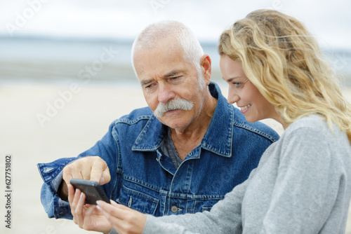 daughter and senior father using a phone