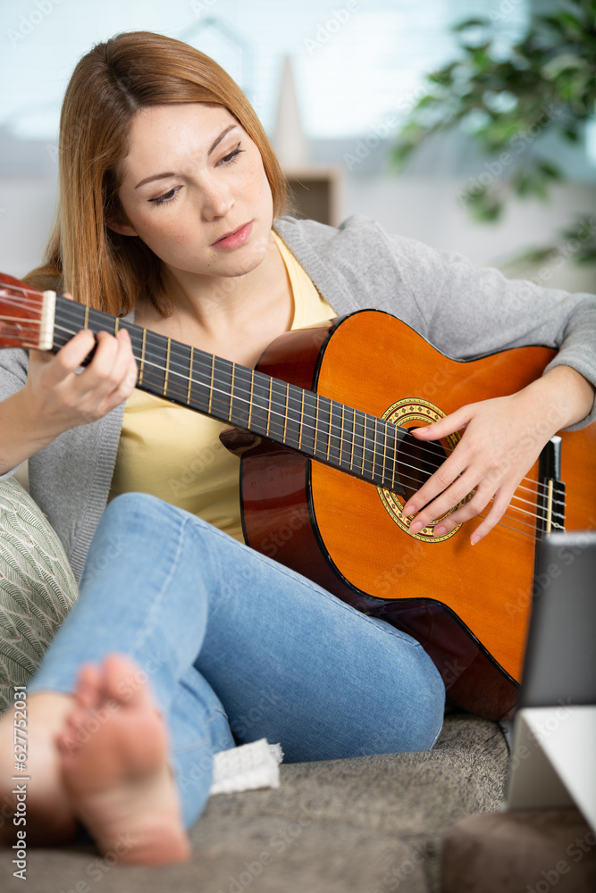 Fototapeta premium pretty girl legs crossed playing some record on guitar