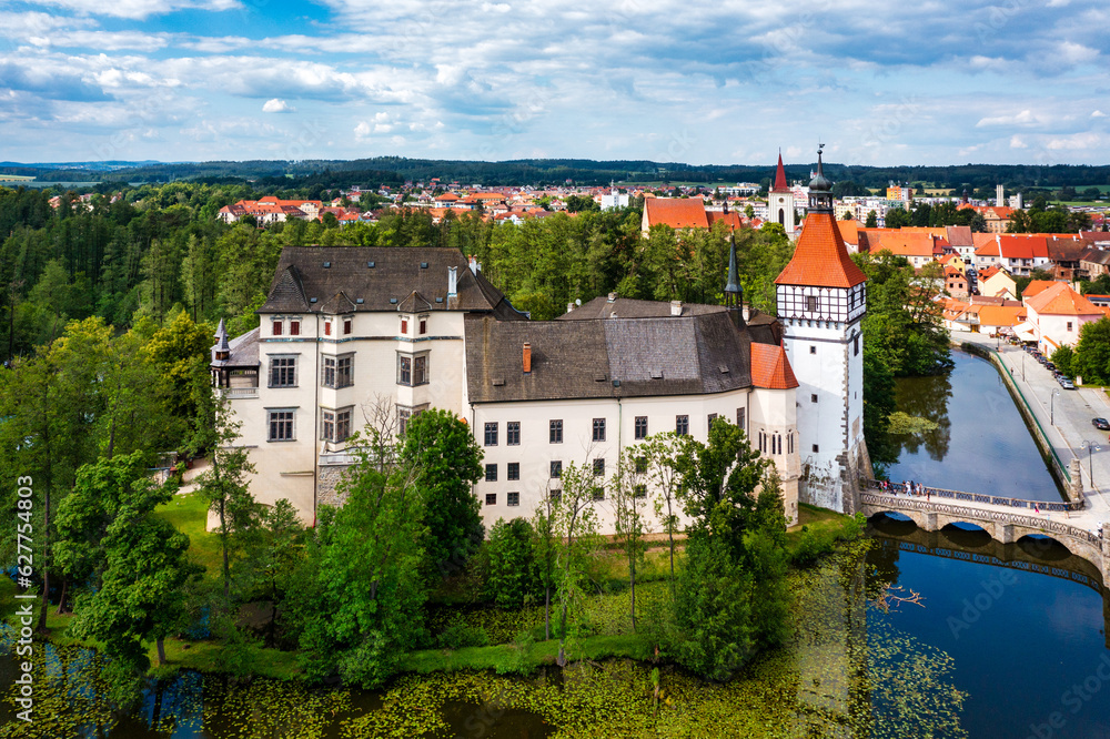 Fototapeta premium Blatna castle near Strakonice, Southern Bohemia, Czech Republic. Aerial view of medieval Blatna water castle surrounded parks and lakes, Blatna, South Bohemian Region, Czech Republic.