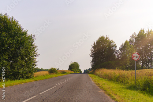 highway road in the countryside, roadside and asphalt, green forest and blue sky on a sunny day 