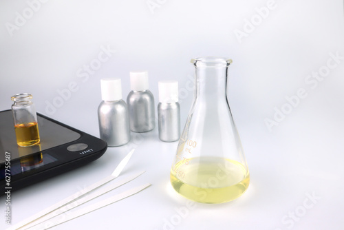 Φωτογραφία chemical beaker , flask is on white table with blotting paper , fragrance bottle
