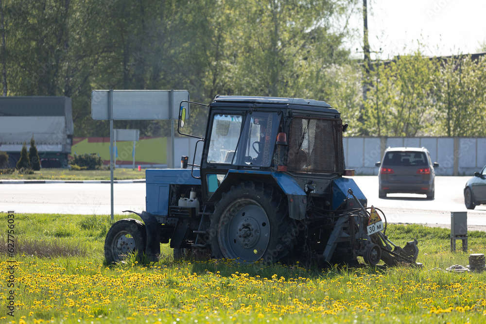 Obraz premium Agricultural tractor on the grass on a sunny day