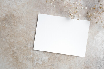Blank wedding invitation card mockup with trendy botanical decor on beige background