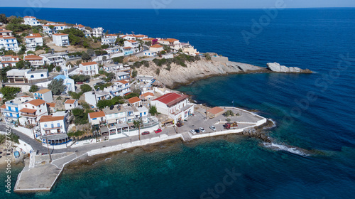 Lovely greek fisher town of Armenistis in a quiet summer morning. Port with local beach in transparent clear water at Ikaria, Greece