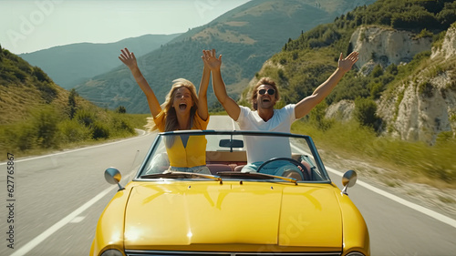 Happy couple driving convertible car on the road - Boyfriend and girlfriend with arms up having fun on a rental auto