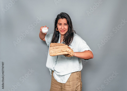 Photography Latin American woman in baseball glove throws baseball