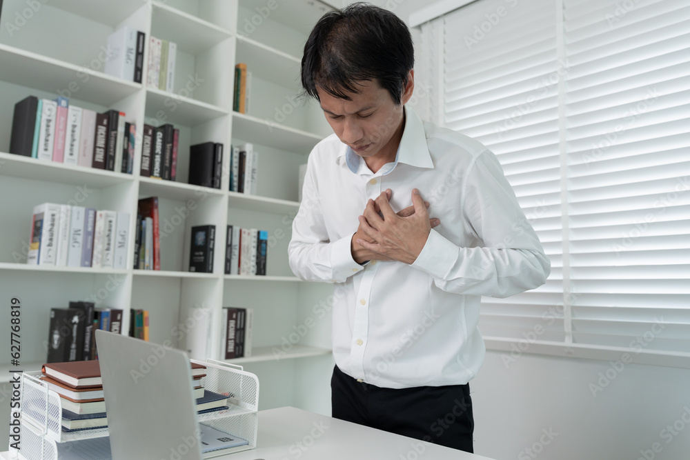 hand hold chest with heart attack symptoms, asian man working hard have